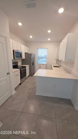 a large kitchen with a large counter top appliances and cabinets