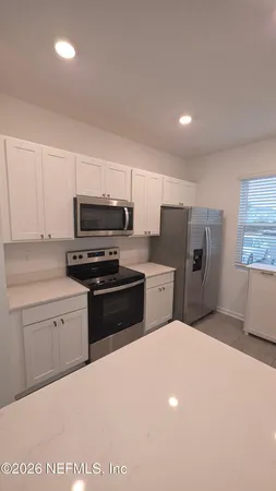 a kitchen with a refrigerator stove and microwave