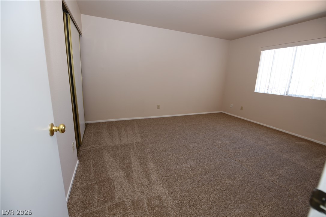 8220 Maplestar Road Las Vegas, NV 89128 - Photo 21 of 29 A spacious, naturally illuminated room featuring ample carpeted floor space.