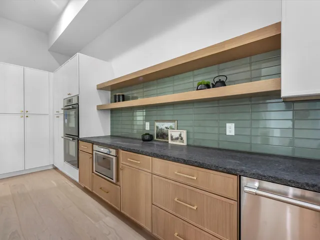 a kitchen with stainless steel appliances granite countertop a sink a stove and a refrigerator