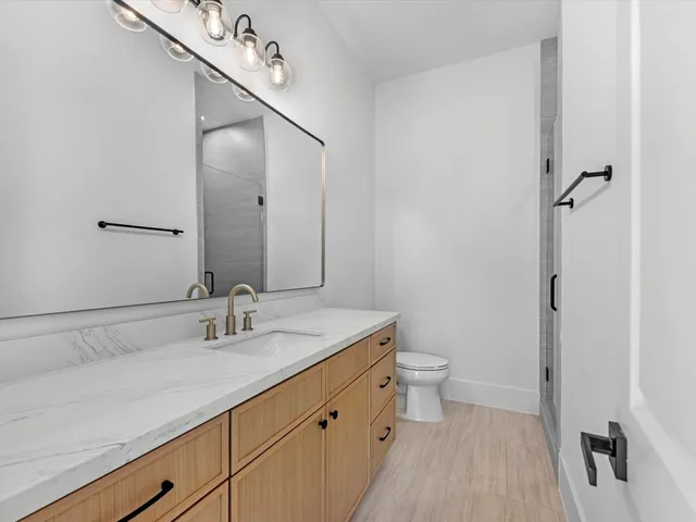 a spacious bathroom with a granite countertop sink mirror and toilet