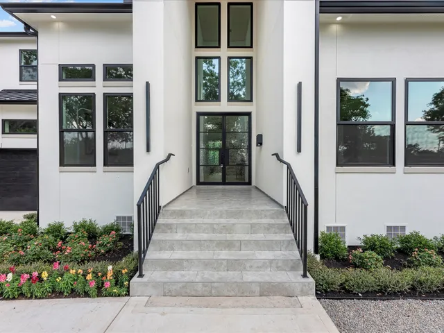 a view of a pathway of a house with potted plants