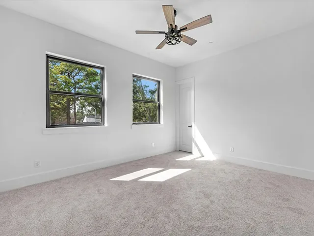 an empty room with fan and windows