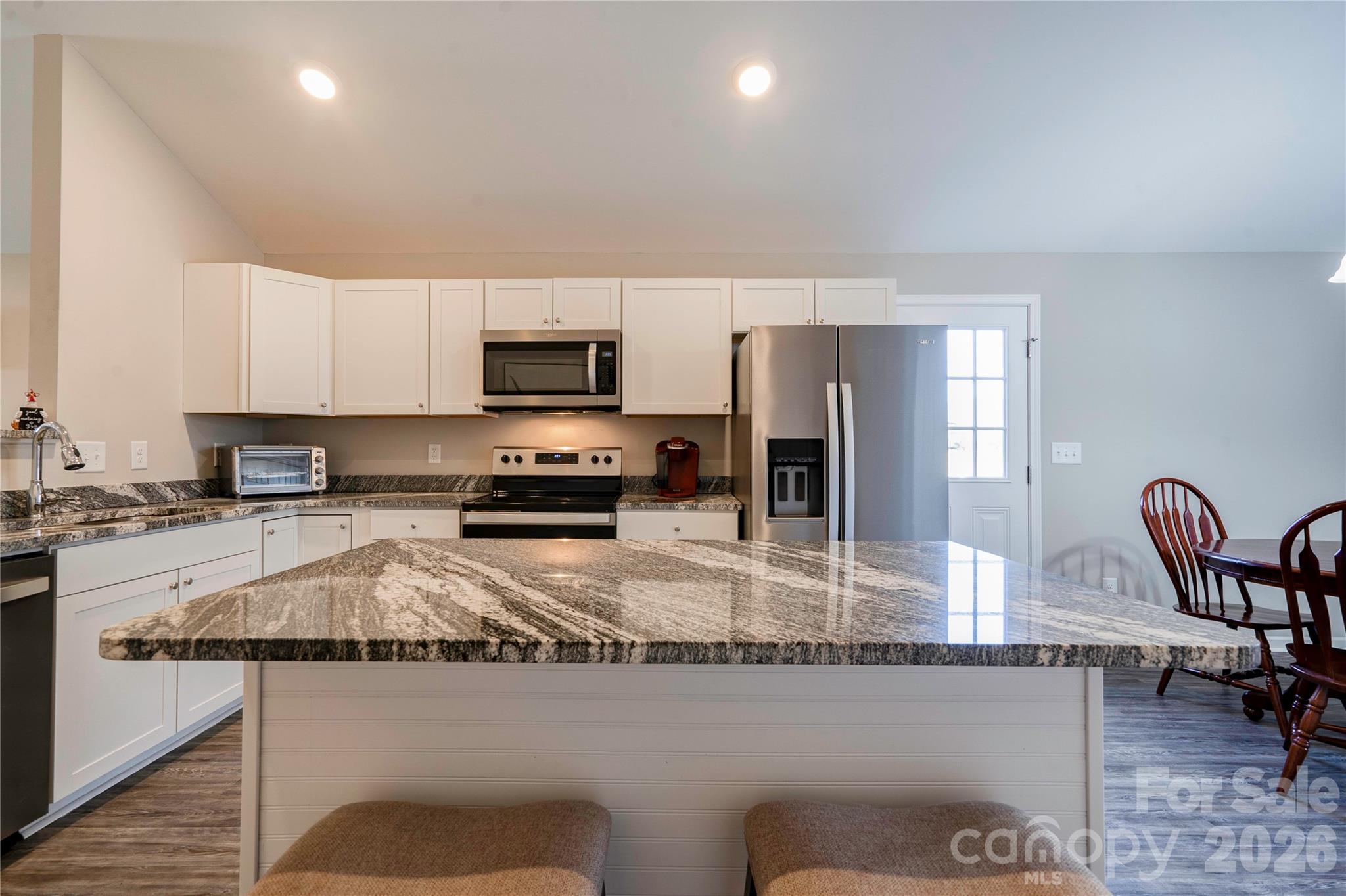 939 Costner Road Shelby, NC 28150 - Photo 7 of 34 a kitchen with stainless steel appliances granite countertop a stove top oven a sink a dining table and chairs