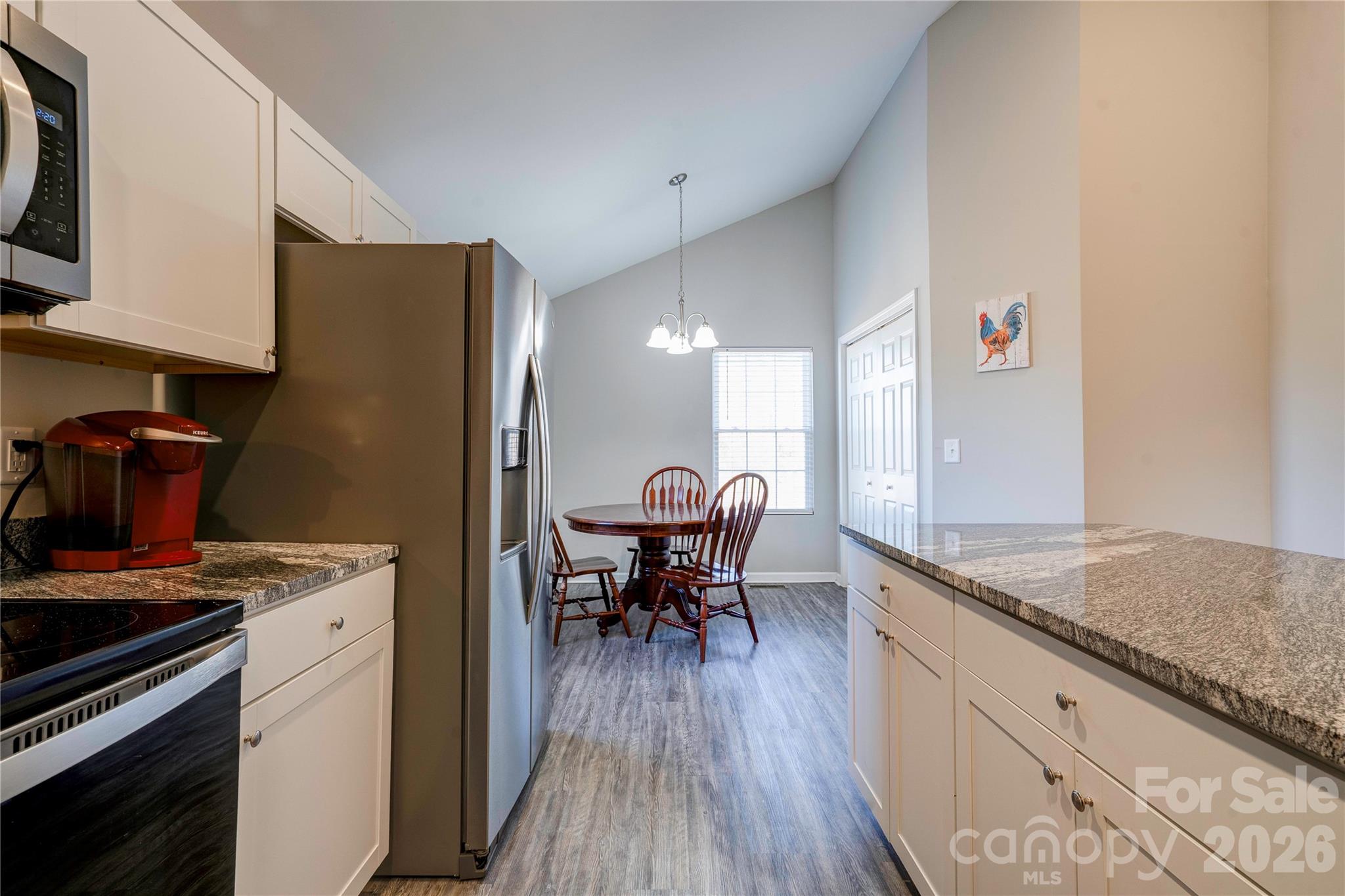 939 Costner Road Shelby, NC 28150 - Photo 9 of 34 a kitchen with stainless steel appliances granite countertop a stove top oven a sink dishwasher and a dining table with wooden floor