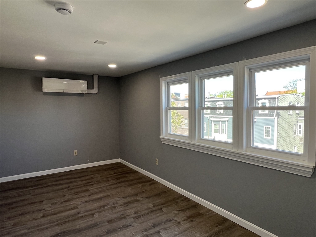 99 Chelsea Street, Unit 3 Boston, MA 02128 - Photo 5 of 10 a view of empty room with wooden floor and fan