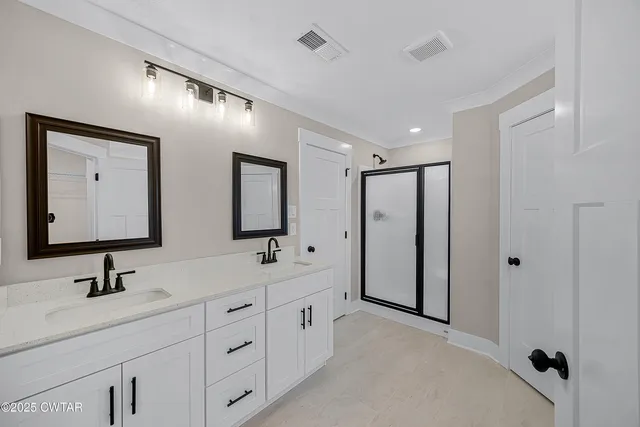 a spacious bathroom with a double vanity sink a mirror and a bathtub