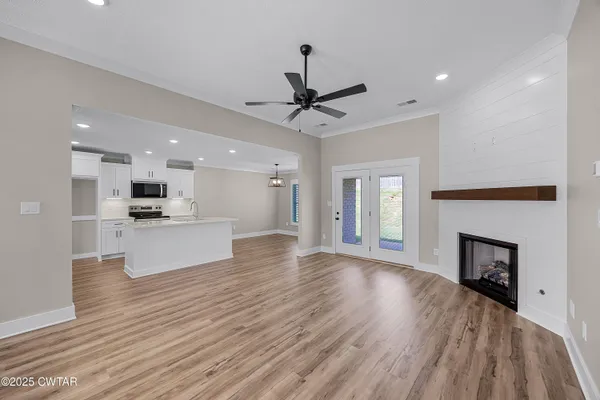 a view of a big room with wooden floor a fireplace and windows