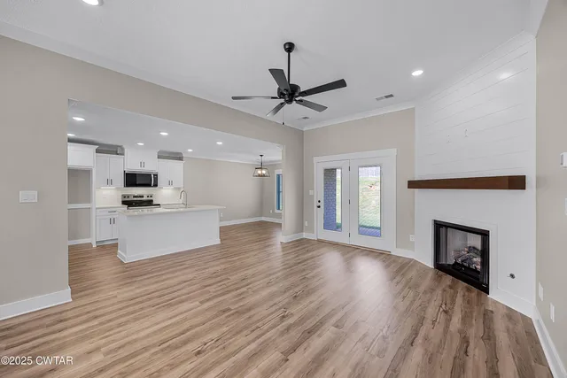 a view of a big room with wooden floor a fireplace and windows