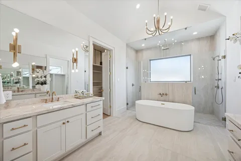 a spacious bathroom with a double vanity sink mirror and bathtub