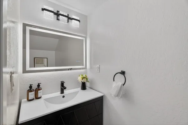 a bathroom with a sink vanity and mirror