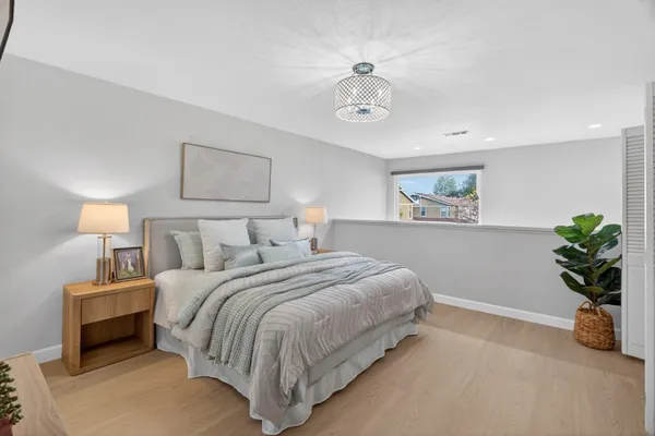 a bedroom with bed and a chandelier