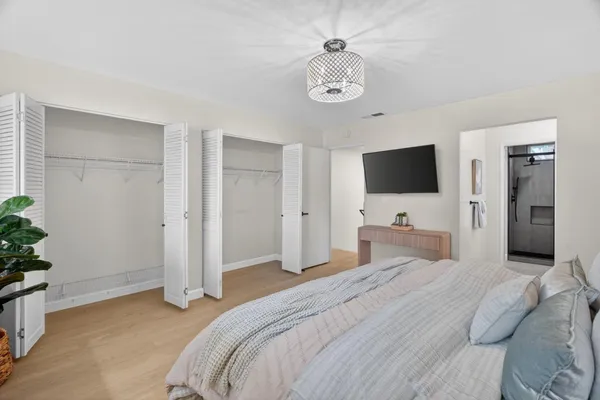 a bedroom with a bed and a flat screen tv