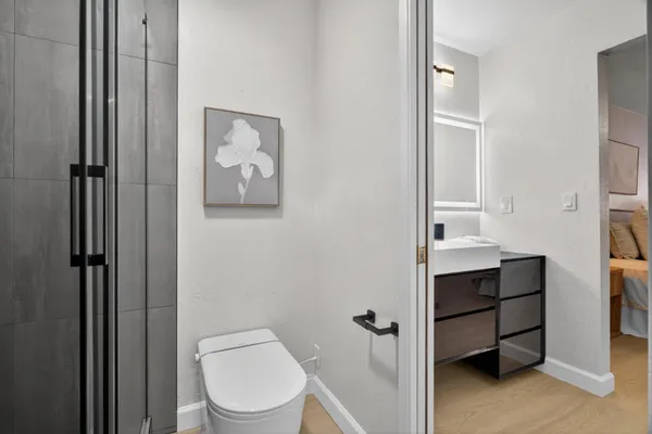a bathroom with a toilet a sink and mirror
