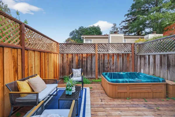a backyard of a house with wooden floor chairs and outdoor seating