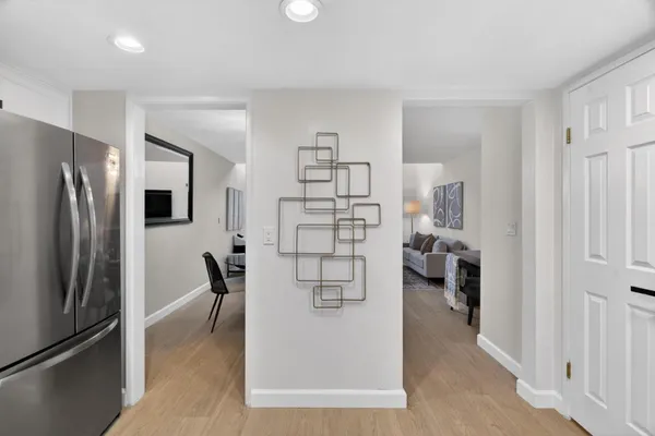a view of a living room a refrigerator and a view of kitchen