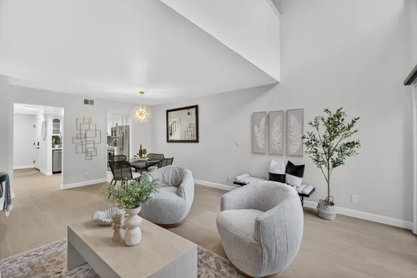 a living room with furniture potted plant and white walls