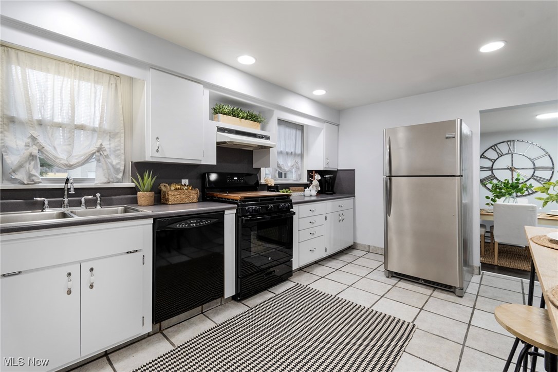 4188 Kirk Road Youngstown, OH 44511 - Photo 13 of 49 Kitchen featuring sink, black appliances, white cabinets, and light tile patterned flooring