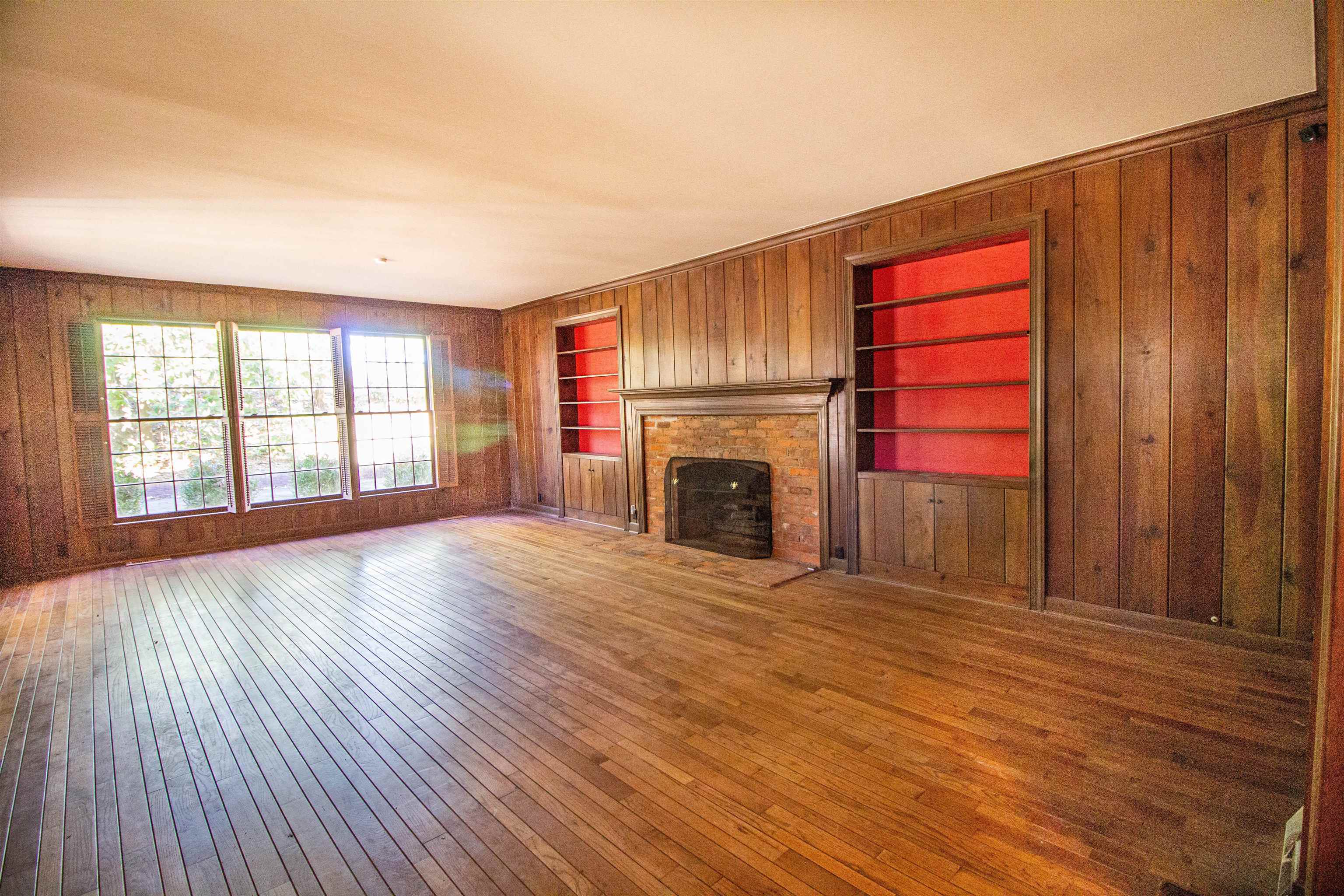 283 Church Street Ripley, TN 38063 - Photo 15 of 36 an empty room with wooden floor fireplace and windows