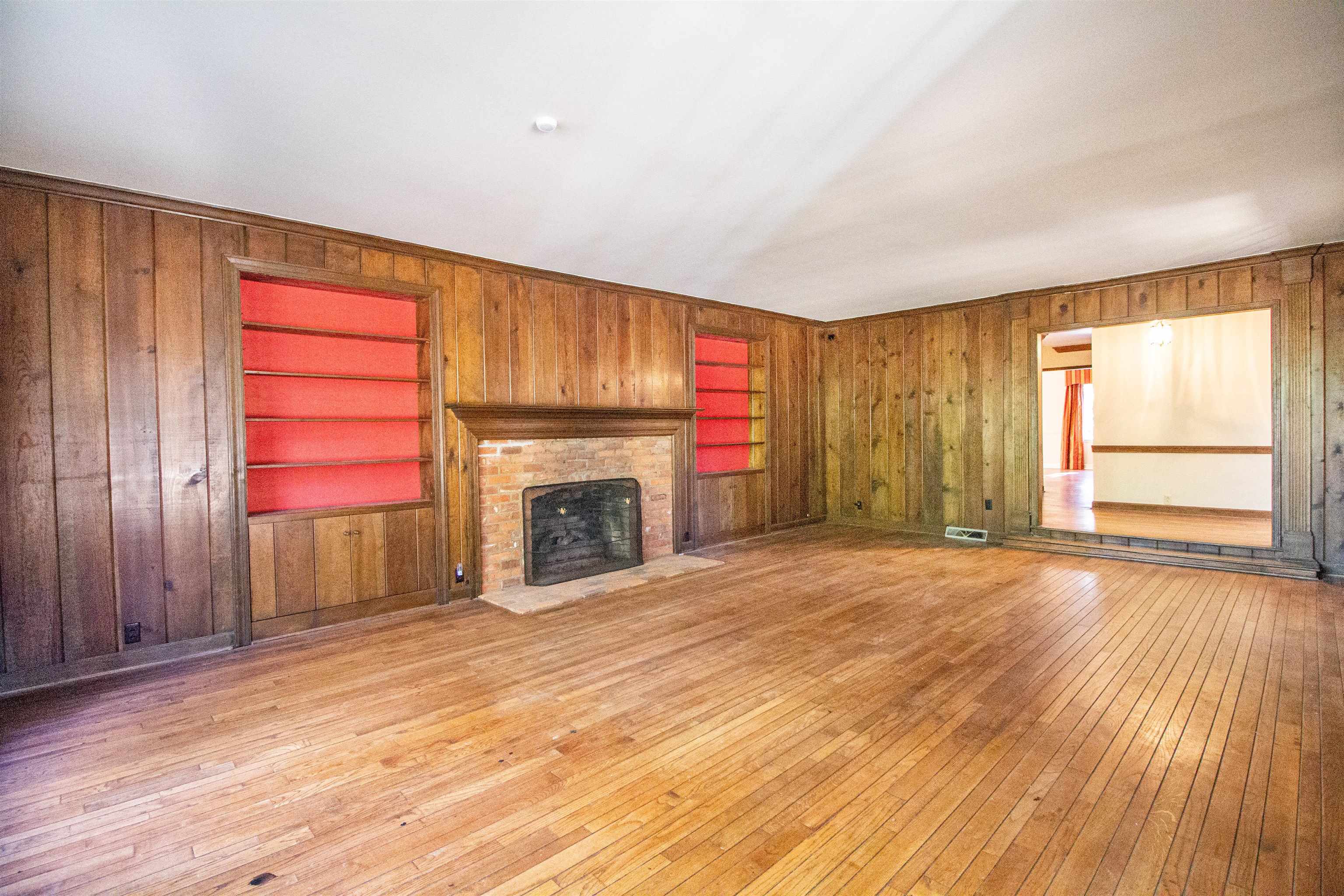 283 Church Street Ripley, TN 38063 - Photo 17 of 36 an empty room with wooden floor fireplace and windows