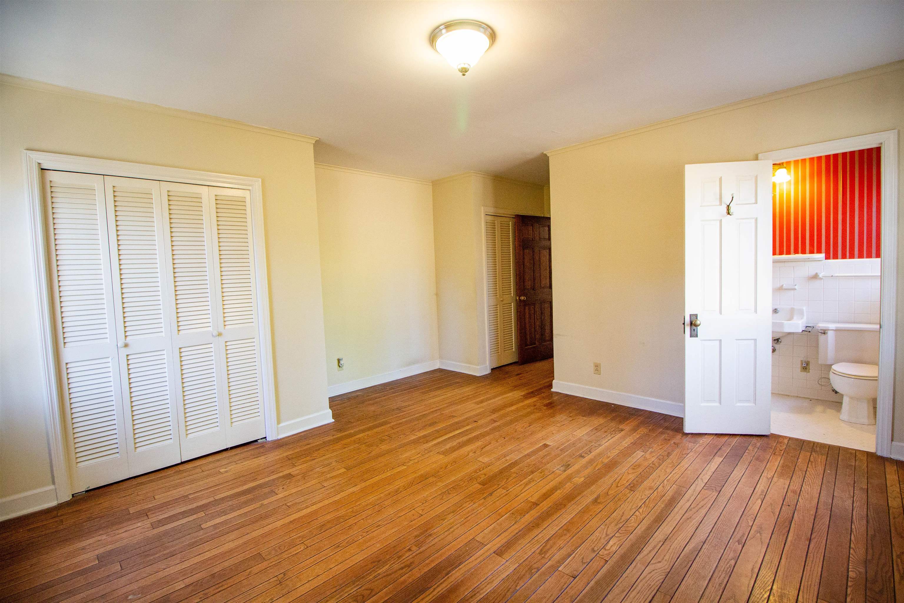 283 Church Street Ripley, TN 38063 - Photo 18 of 36 an empty room with wooden floor and windows