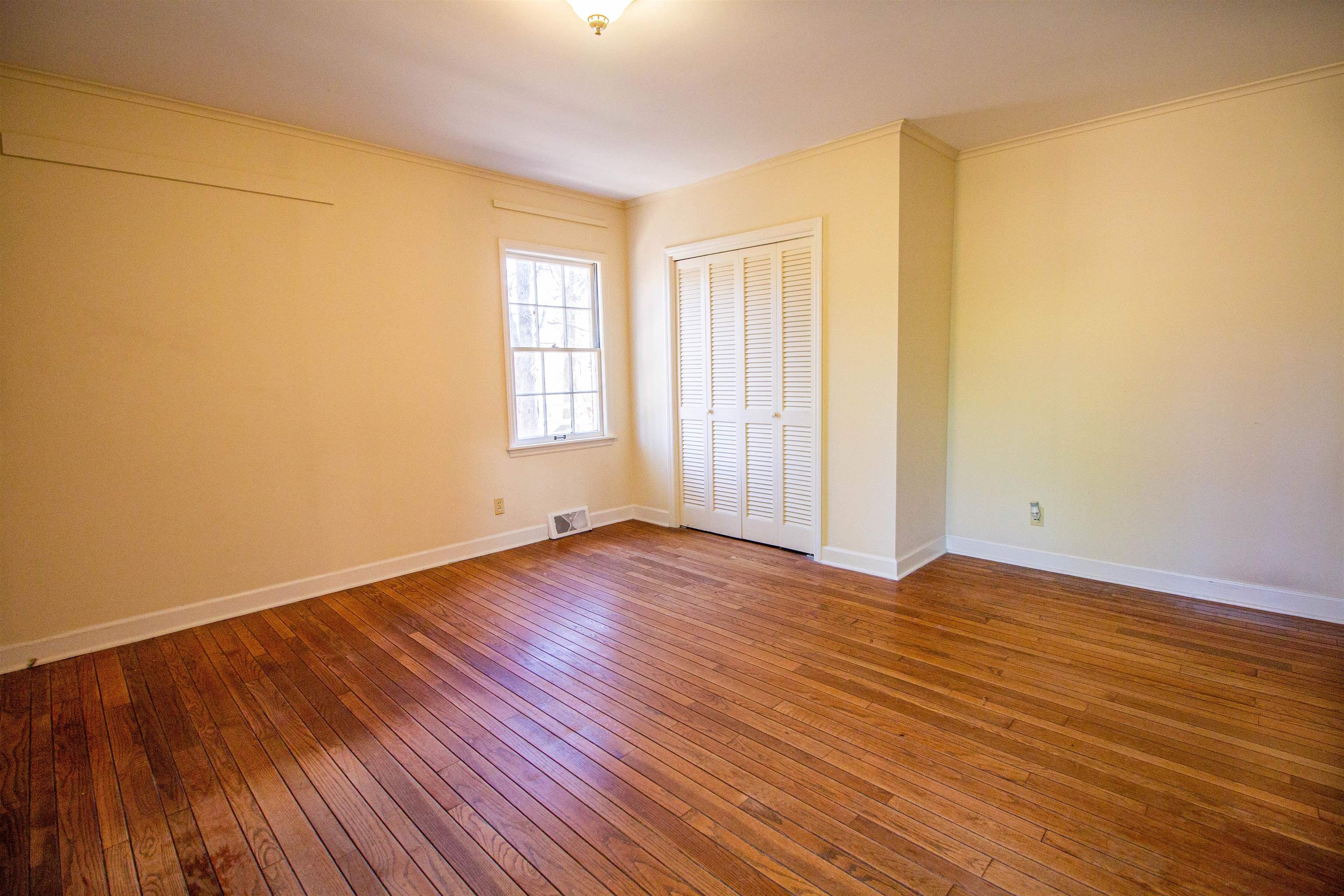 283 Church Street Ripley, TN 38063 - Photo 19 of 36 an empty room with wooden floor and windows