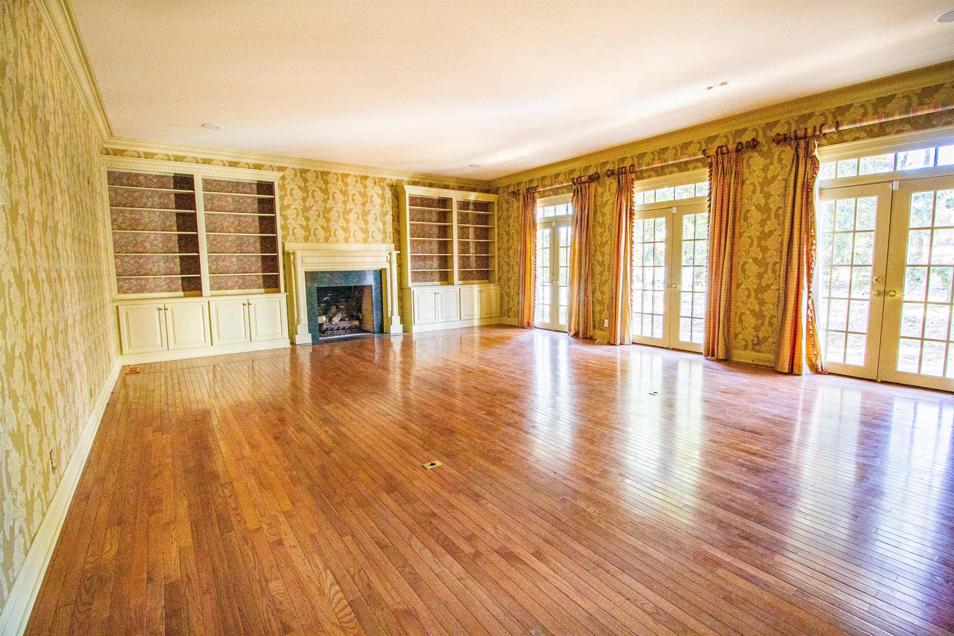 283 Church Street Ripley, TN 38063 - Photo 5 of 36 an empty room with wooden floor and large windows