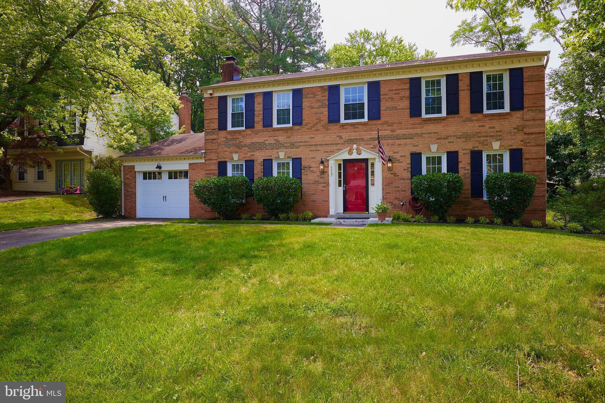 a front view of a house with a yard and trees