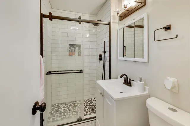 a bathroom with a shower toilet and sink