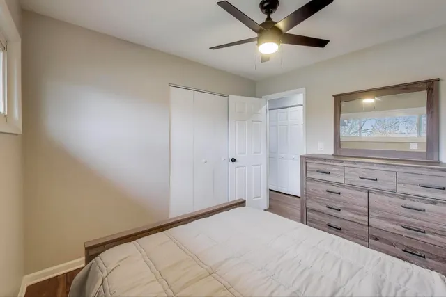 a bedroom with a bed and a mirror on the dresser