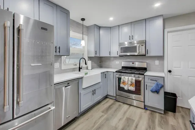 a kitchen with stainless steel appliances a sink cabinets and a refrigerator