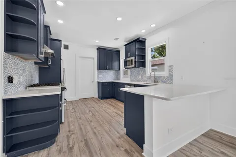 a kitchen with stainless steel appliances kitchen island granite countertop a sink and cabinets