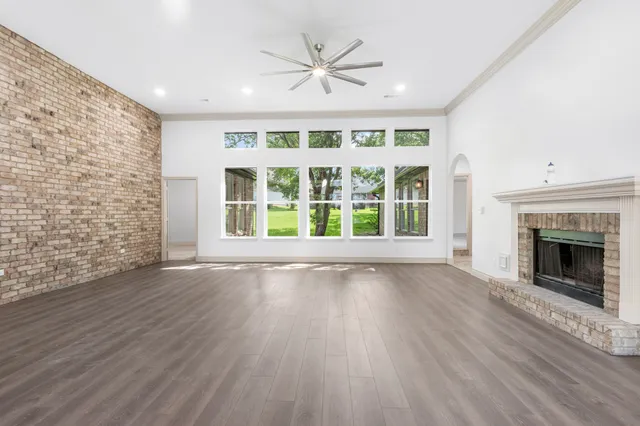 wooden floor fireplace and windows in an empty room