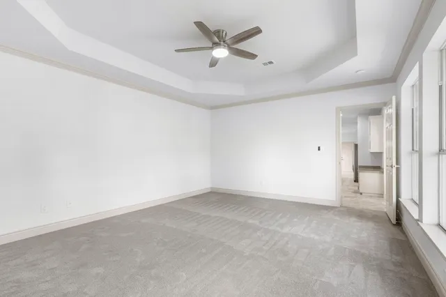 an empty room with closet and a ceiling fan