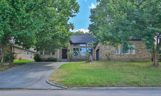 a view of a house with a yard and tree s