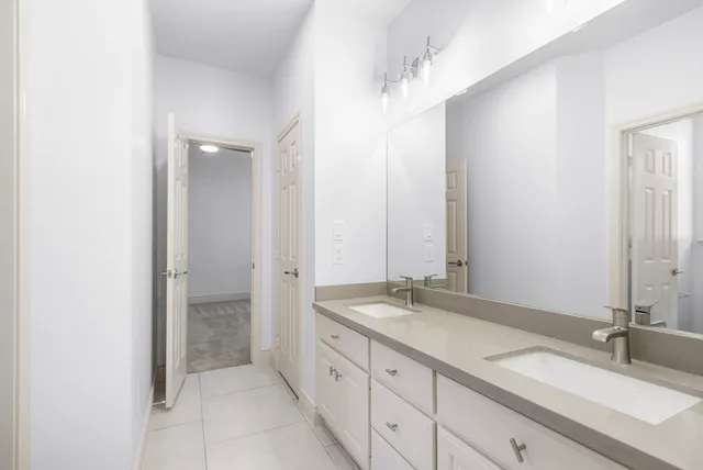 a bathroom with double sink and a mirror