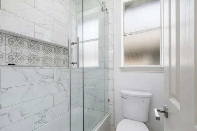 a bathroom with a toilet and a shower