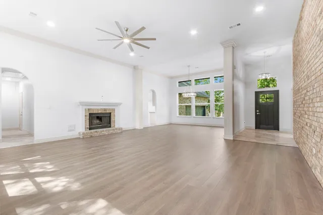 an empty room with windows and a ceiling fan