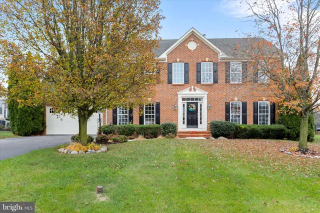 a front view of a house with a yard and trees
