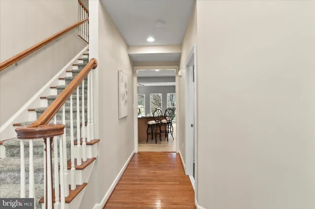 a view of a hallway with wooden floor and staircase