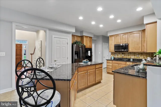 a large kitchen with granite countertop lots of counter space and windows