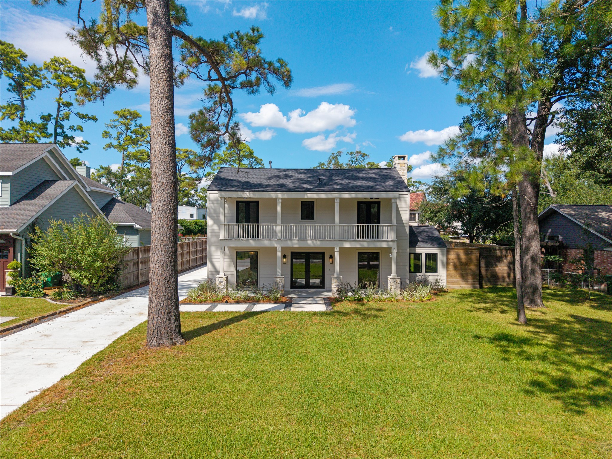 Another perspective of the front elevation, highlighting the timeless architecture and tree-lined setting
