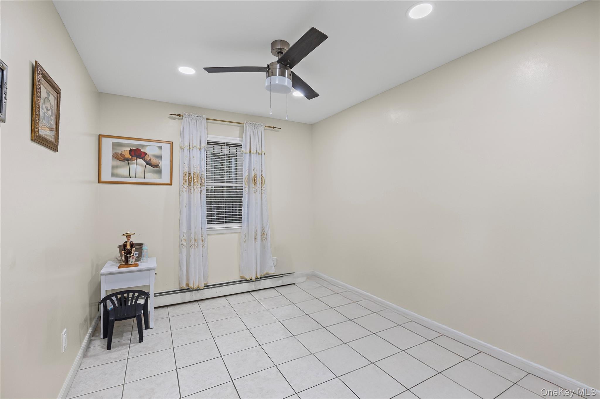 79 Union Place Hempstead, NY 11550 - Photo 11 of 26 Empty room with baseboard heating, recessed lighting, light tile patterned flooring, and ceiling fan