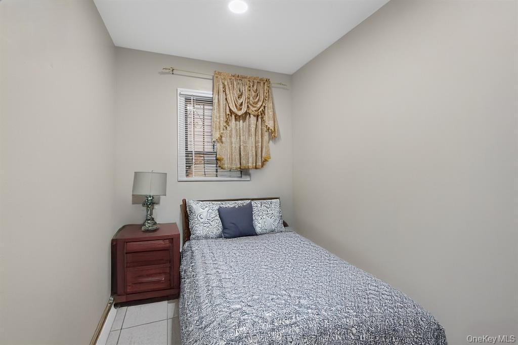 79 Union Place Hempstead, NY 11550 - Photo 12 of 26 Bedroom featuring light tile patterned floors and baseboards