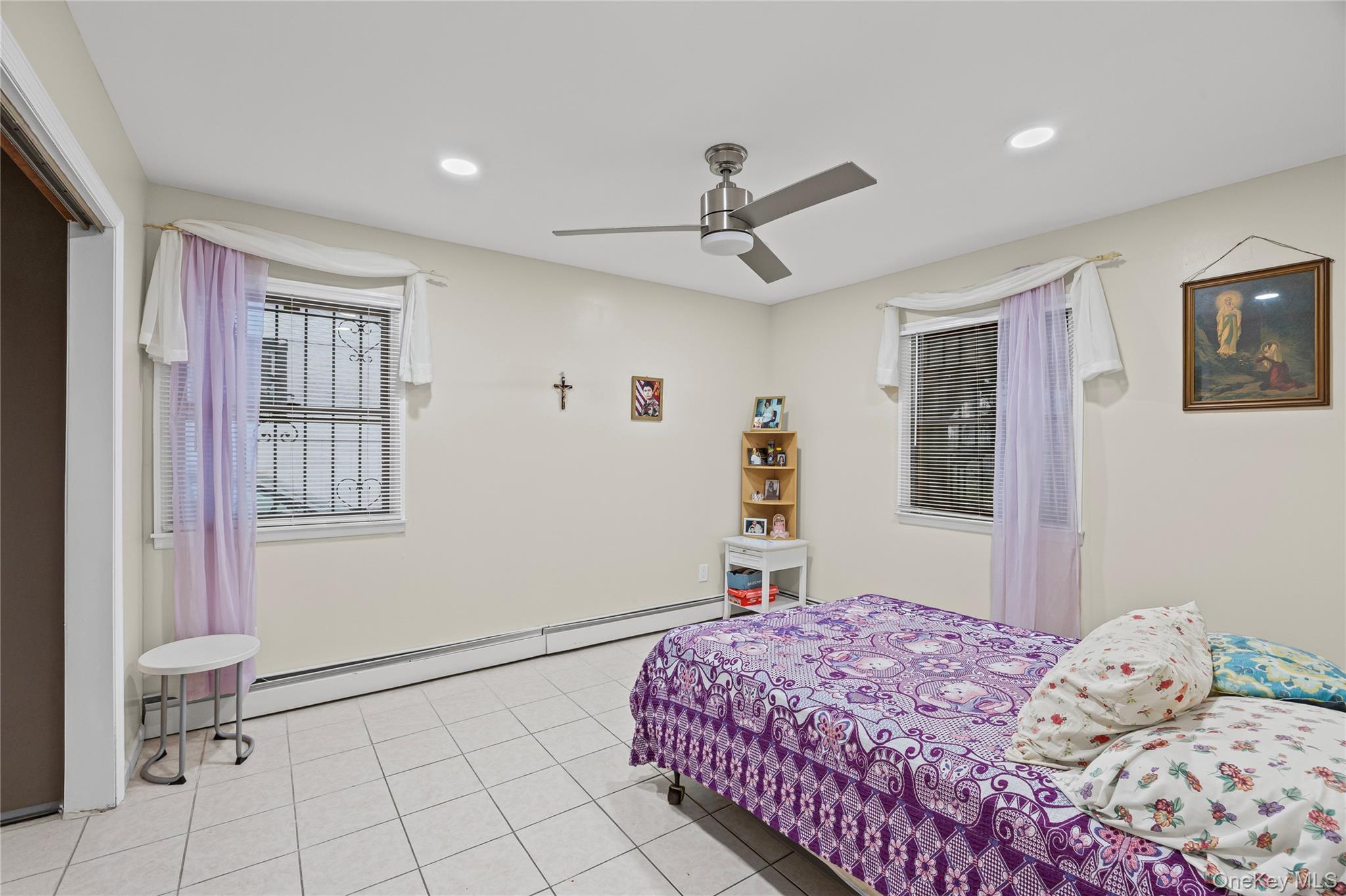 79 Union Place Hempstead, NY 11550 - Photo 16 of 26 Bedroom featuring a baseboard heating unit, a ceiling fan, recessed lighting, and tile patterned flooring
