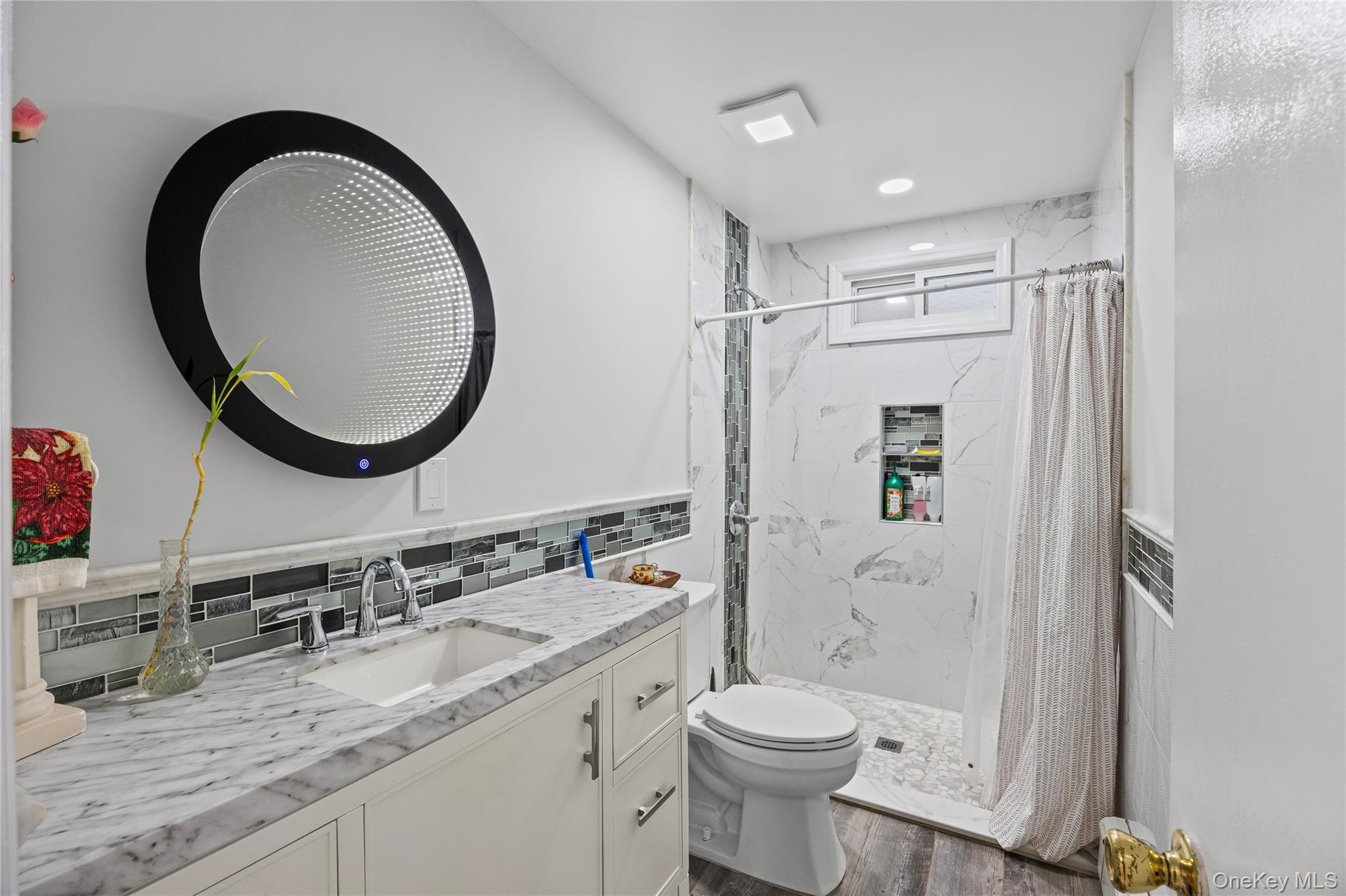 79 Union Place Hempstead, NY 11550 - Photo 18 of 26 Bathroom featuring vanity, a marble finish shower, and backsplash