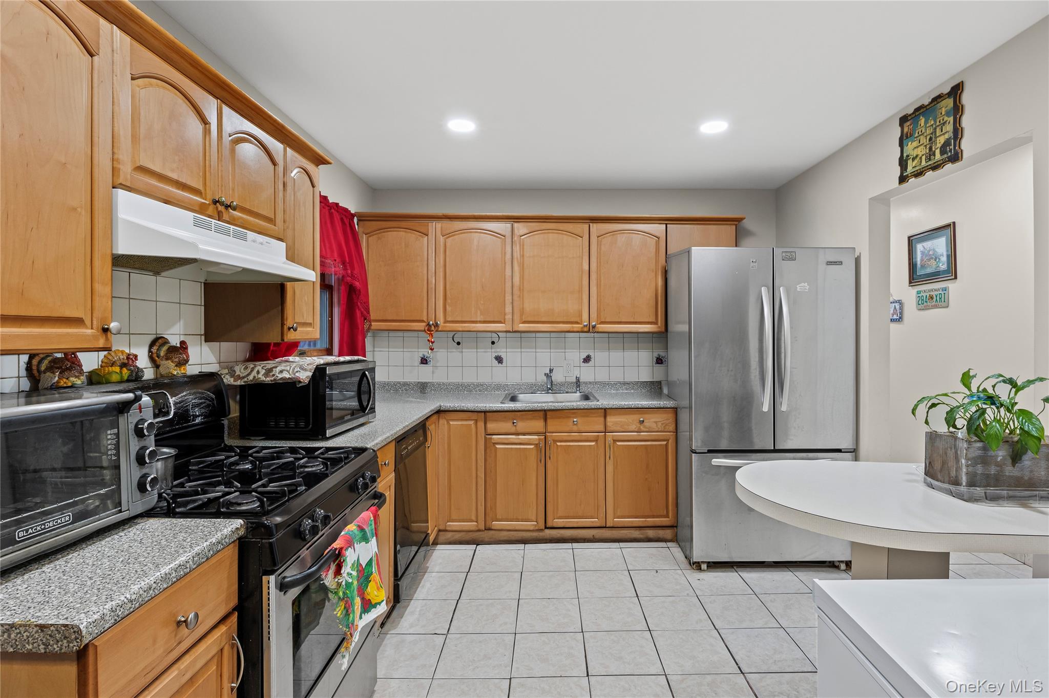 79 Union Place Hempstead, NY 11550 - Photo 3 of 26 Kitchen featuring black appliances, under cabinet range hood, tasteful backsplash, light tile patterned floors, and recessed lighting