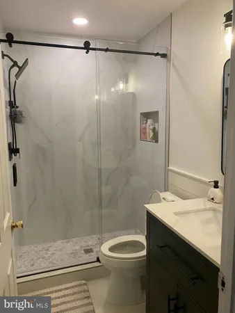 a bathroom with a sink a toilet and shower