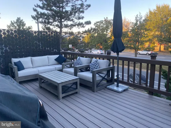 a roof deck with couches and wooden fence