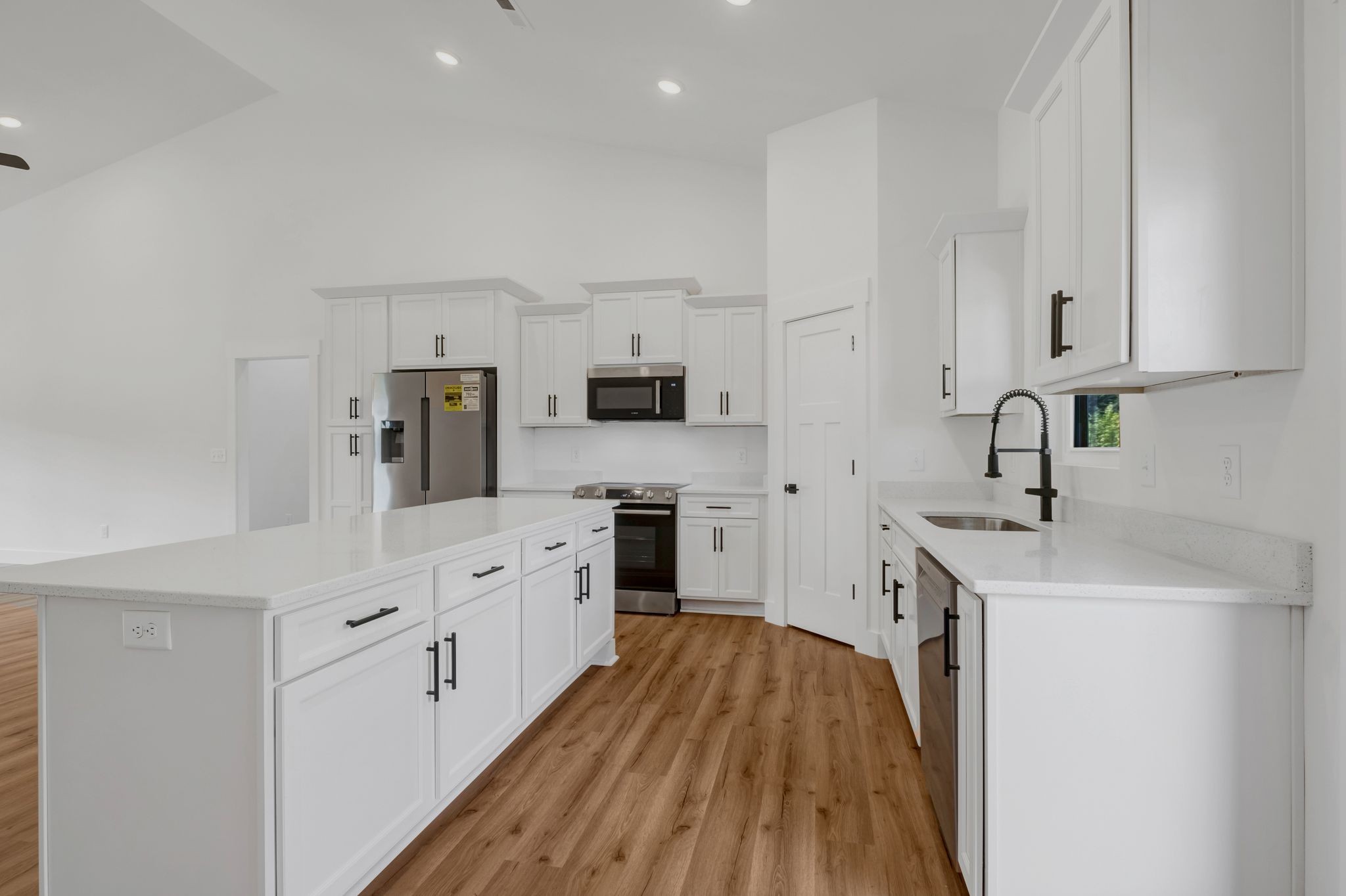 5050 Richards Road Adams, TN 37010 - Photo 13 of 52 a kitchen with stainless steel appliances a white stove top oven a sink a refrigerator and white cabinets with wooden floor